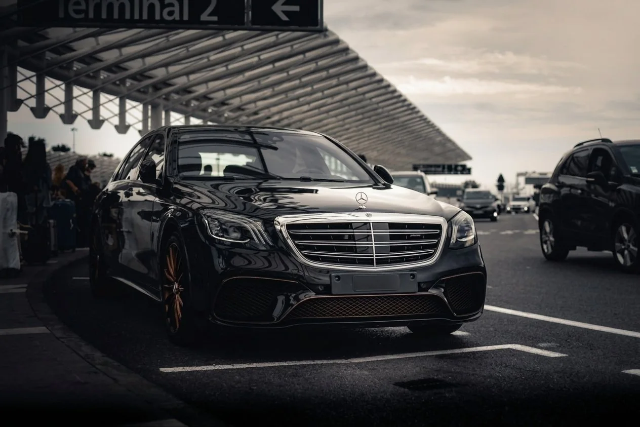 Berline Mercedes noire au terminal de l'aéroport pour un transfert privé